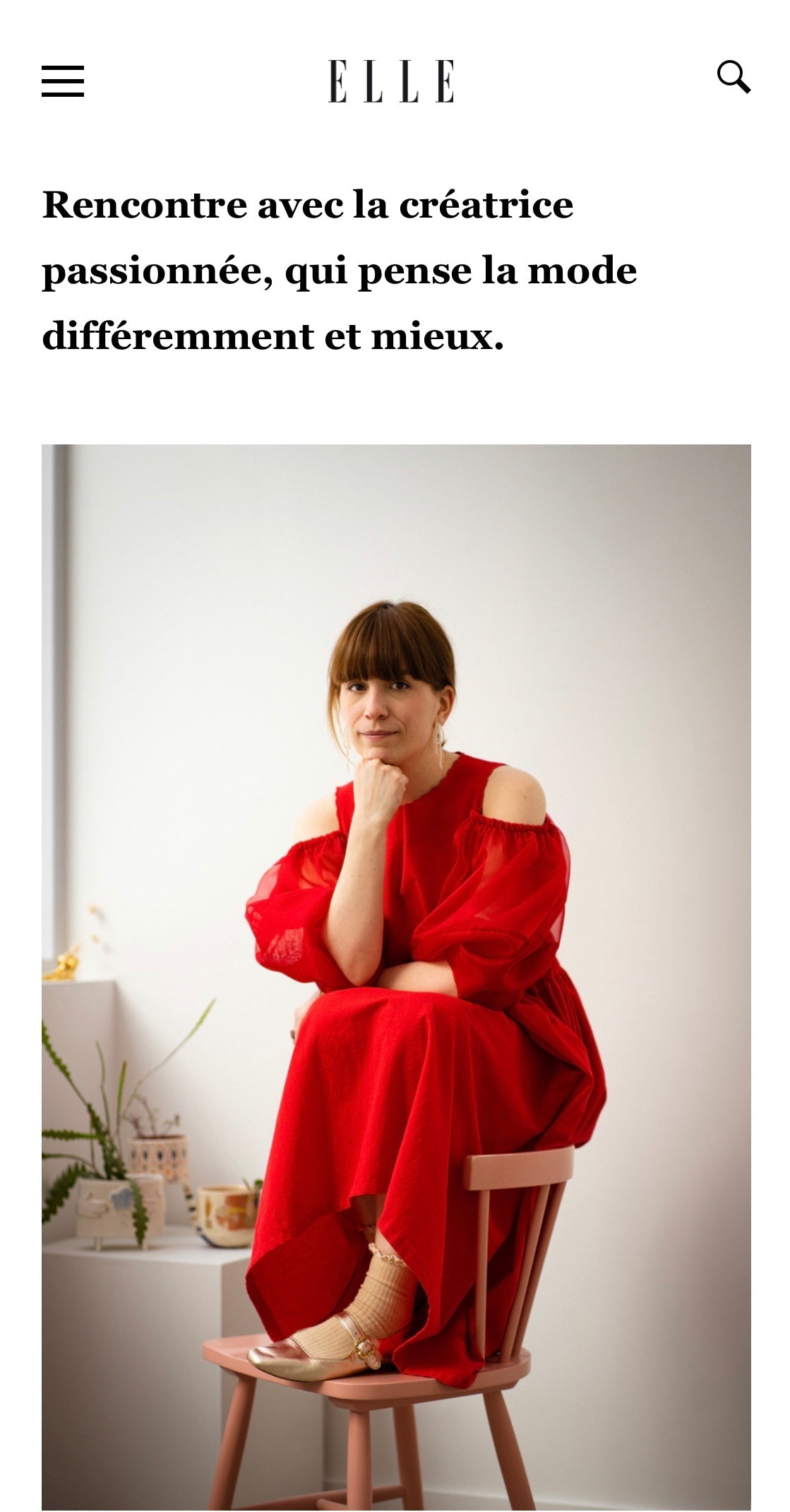 A woman in the refined Billie Dress by Noémiah sits on a chair, resting her chin on her hand. She is in a minimalist room with a small plant and decorative items on a shelf. The text is in French, emphasizing an encounter with an enthusiastic fashion creator.