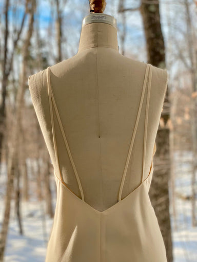 Noémiah Claude dress on mannequin in forest background.