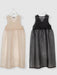 Two sleeveless Noémiah Coco Silk Dresses are displayed on hangers against a light gray background. The relaxed fit of the beige dress on the left and the black one on the right beautifully complements their silk organza flared skirts and V-necklines.