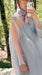 A person takes a mirror selfie outdoors in the Noémiah Flavie Shirt Dress — Classic, a sheer, oversized silk organza maxi with a high collar and red trim in light lavender. Blurred green trees are visible in the background.
