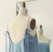 Noémiah Florence Top in light blue Tencel, featuring thin tie-shoulder straps and a low-cut back, displayed on a dress form.