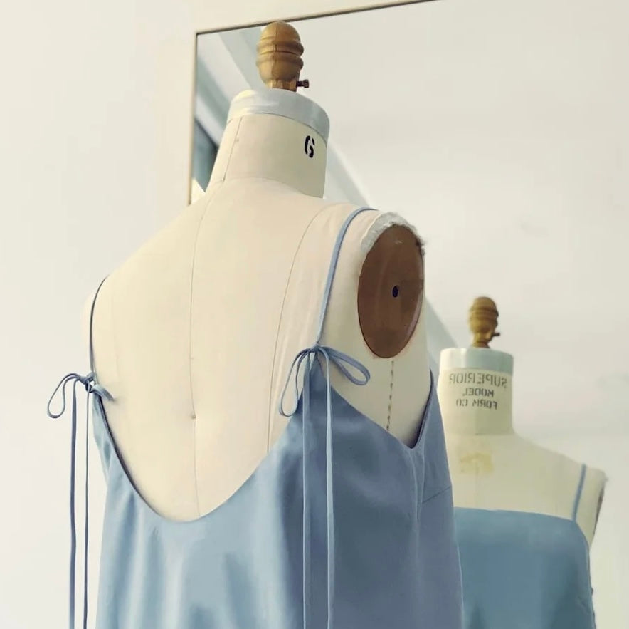 Noémiah Florence Top in light blue Tencel, featuring thin tie-shoulder straps and a low-cut back, displayed on a dress form.