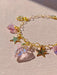 The Henriette Bracelet, from the brand Noémiah, is a gold chain bracelet with exquisite gold-plating and features charming Swarovski crystal heart and star charms. Elegantly displayed on a light surface, these crystals beautifully catch the light, highlighting their colorful and shiny appearance.