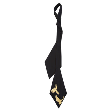 Introducing the "Iris Necktie" by Noémiah, a handcrafted accessory in black with an asymmetrical design made from luxurious silk cotton. It showcases two exquisite golden embroidered bird motifs near the tip, making it an ideal choice for women looking to add a sophisticated flair to any outfit.