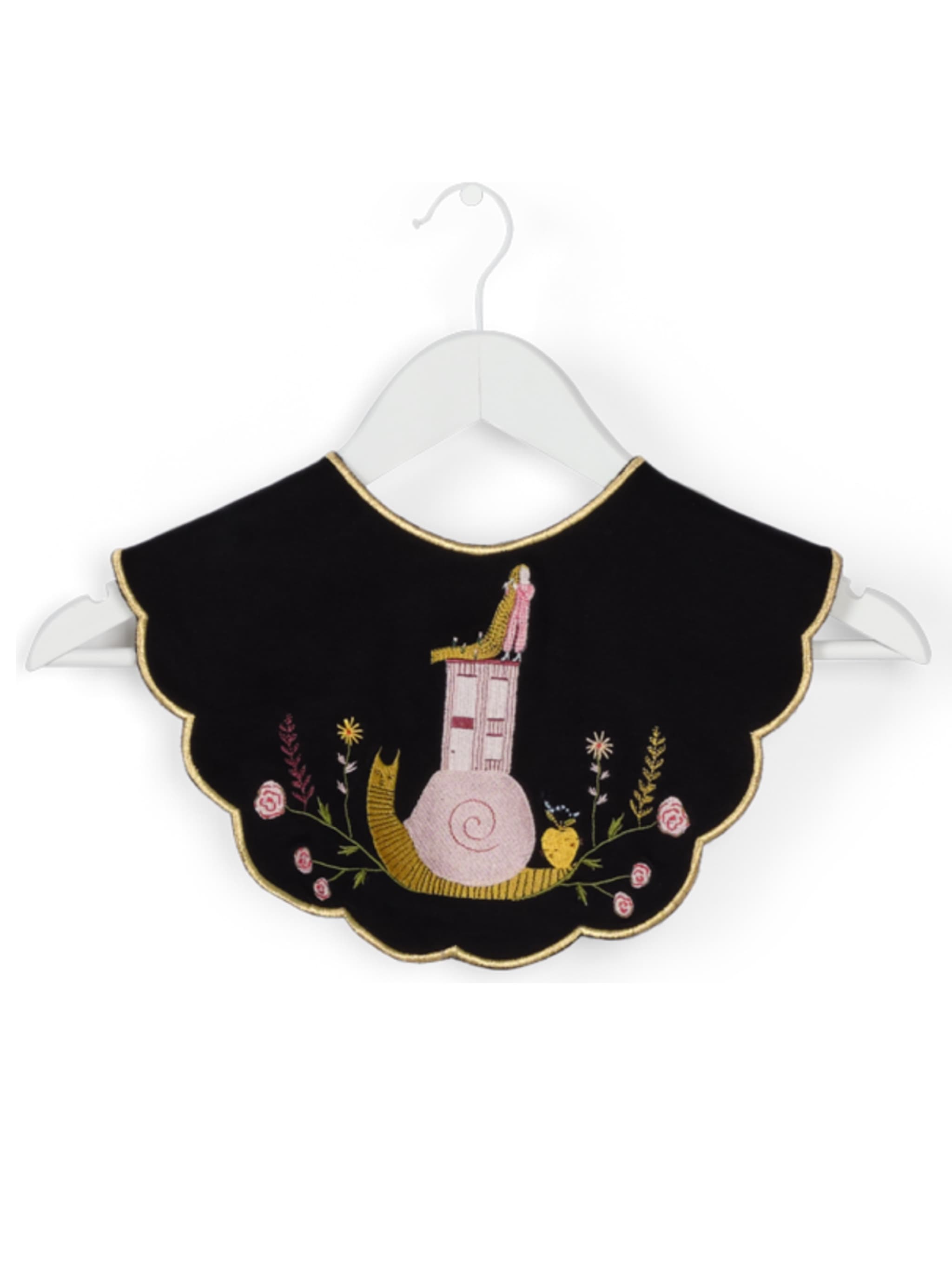 The Olivia Black Collar — Snail on the Back by Noémiah is a delightful baby bib featuring elaborate embroidery of a house perched on a large pink snail, encircled by colorful flowers, leaves, and a tiny bird. This charming accessory, presented on a white hanger against a simple backdrop, is an enchanting addition to any little one's wardrobe.