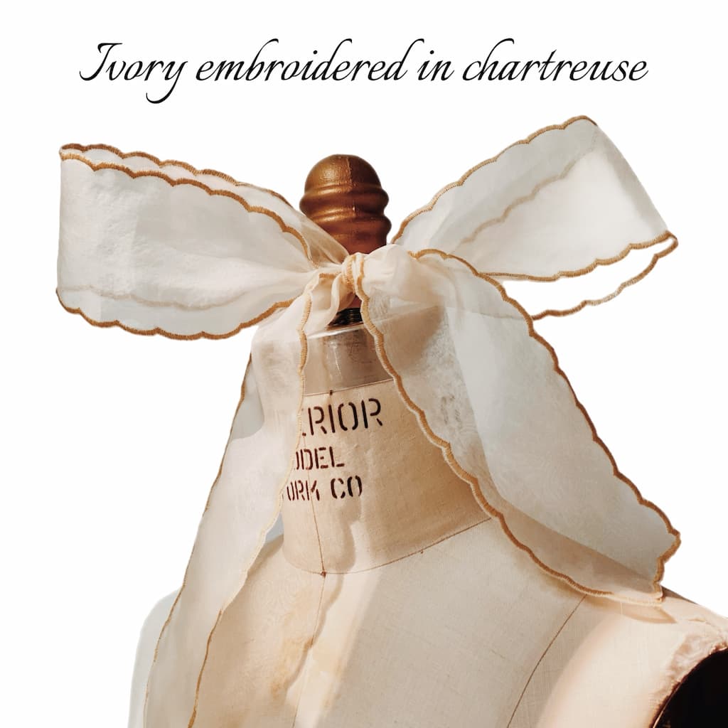 An ivory Silk Ribbon — Classic by Noémiah, with chartreuse scalloped embroidery, is tied in a large bow on a dress form. “Ivory embroidered in chartreuse” appears at the top, highlighting this elegant silk accessory.