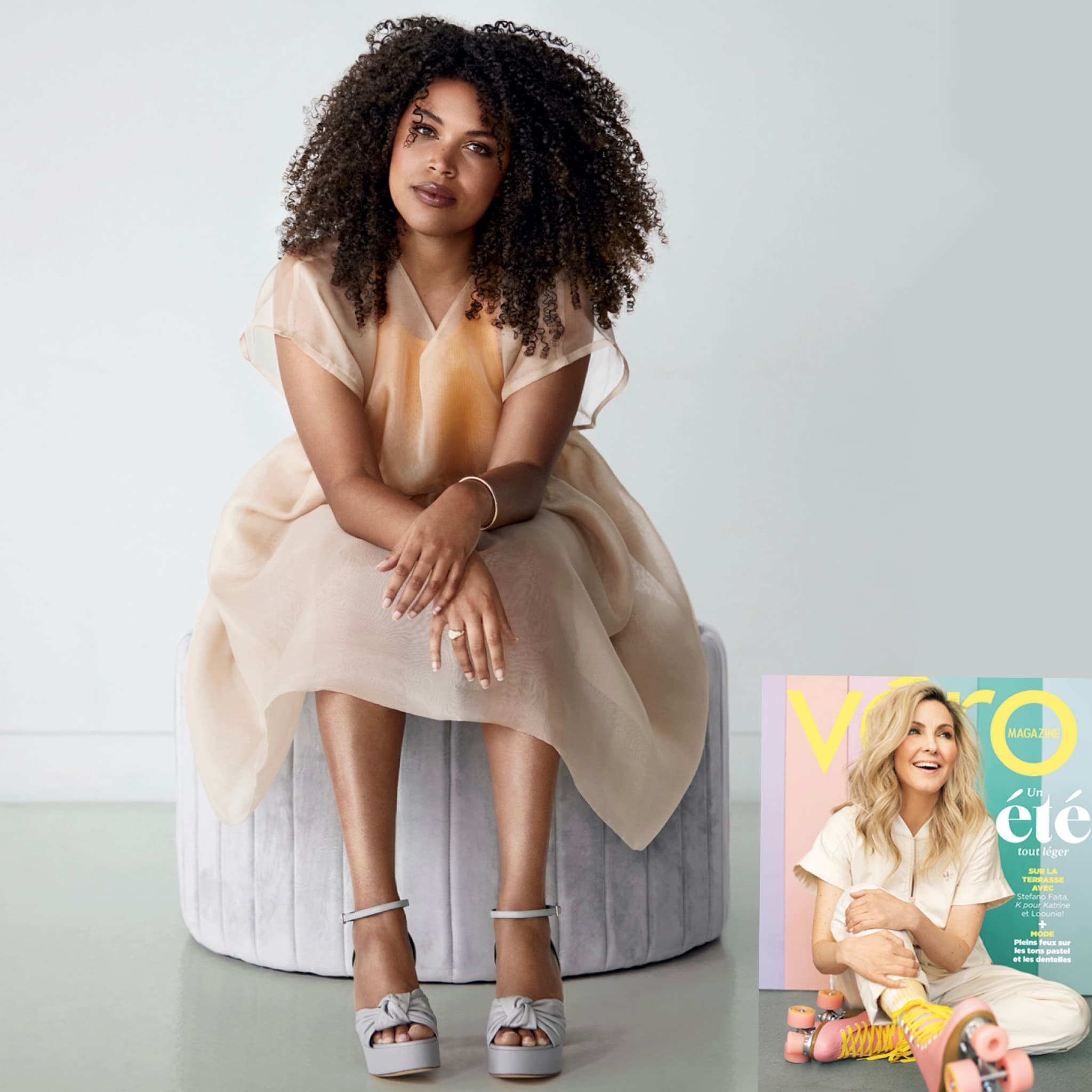 A woman with curly hair sits on a round ottoman, wearing a sheer beige Tulip Dress by noemiah and silver platform sandals. In the bottom right corner, there's a small image of a magazine cover featuring a smiling woman in light, relaxed-fit clothing.