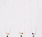 Three minimalist necklaces from noemiah's Urso Necklace collection include options A, B, and C. Necklace A features a cube and spherical pendant; Necklace B highlights two spherical pendants; and Necklace C presents a cylindrical rod alongside a circular pendant. Each necklace is set on a delicate chain with tarnish-resistant plating to ensure lasting shine.